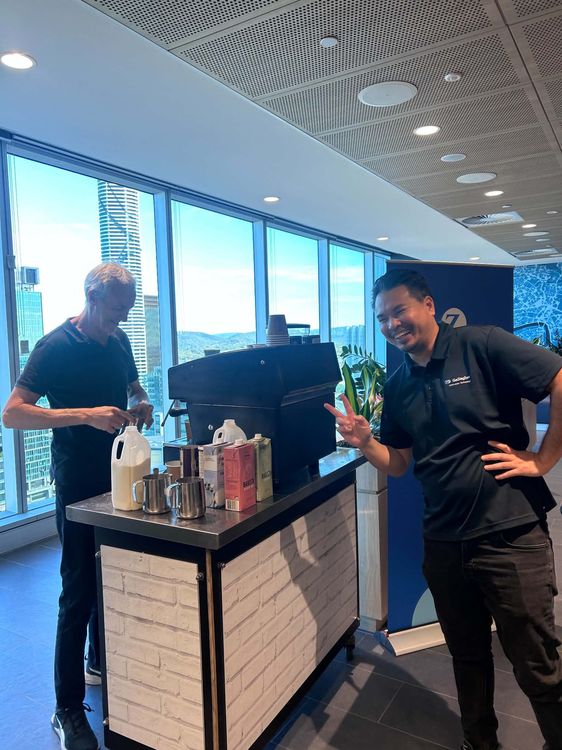 Event Coffee Catering & Juice team serving coffee at a Brisbane CBD corporate event with city skyline view