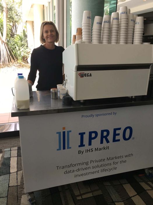 IPREO by IHS Markit — professional barista behind white Wega espresso machine at a corporate event