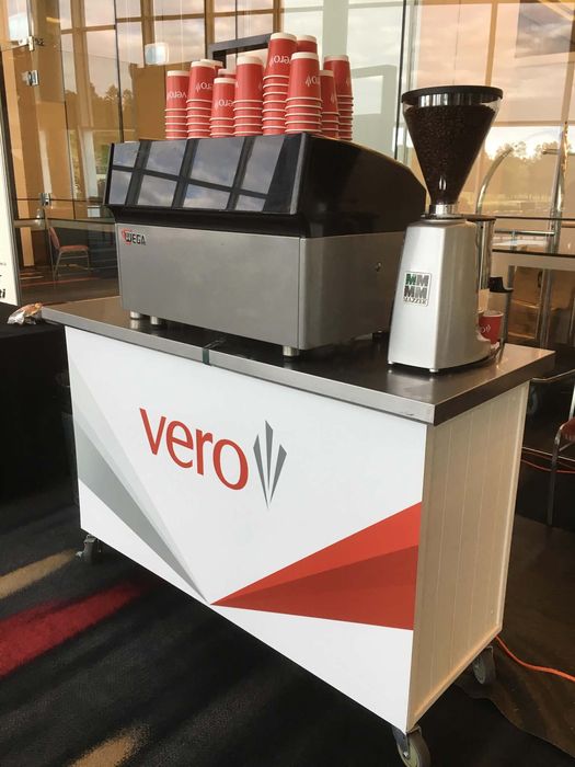 Vero branded mobile espresso cart with Wega machine and Mazzer grinder at a corporate conference venue